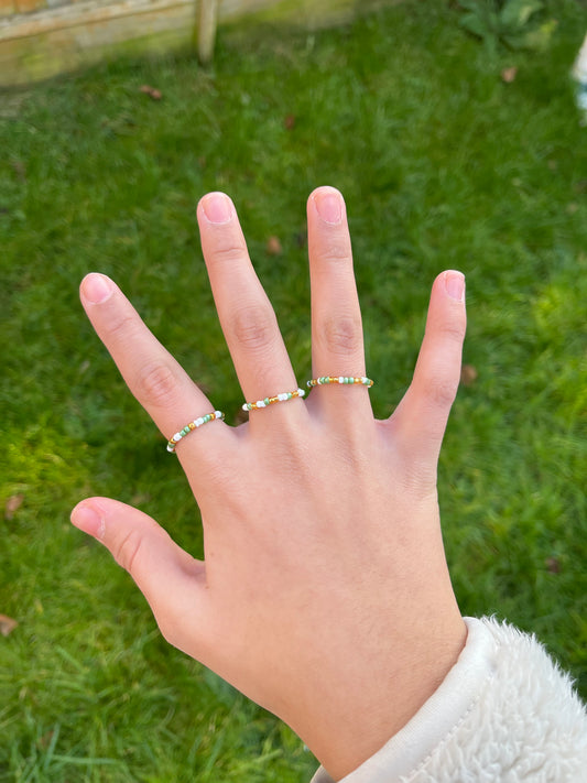 White, gold and green beaded ring set